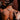 Person with tattoos on their back and arms, wearing silver choker with emerald stone and two tigers